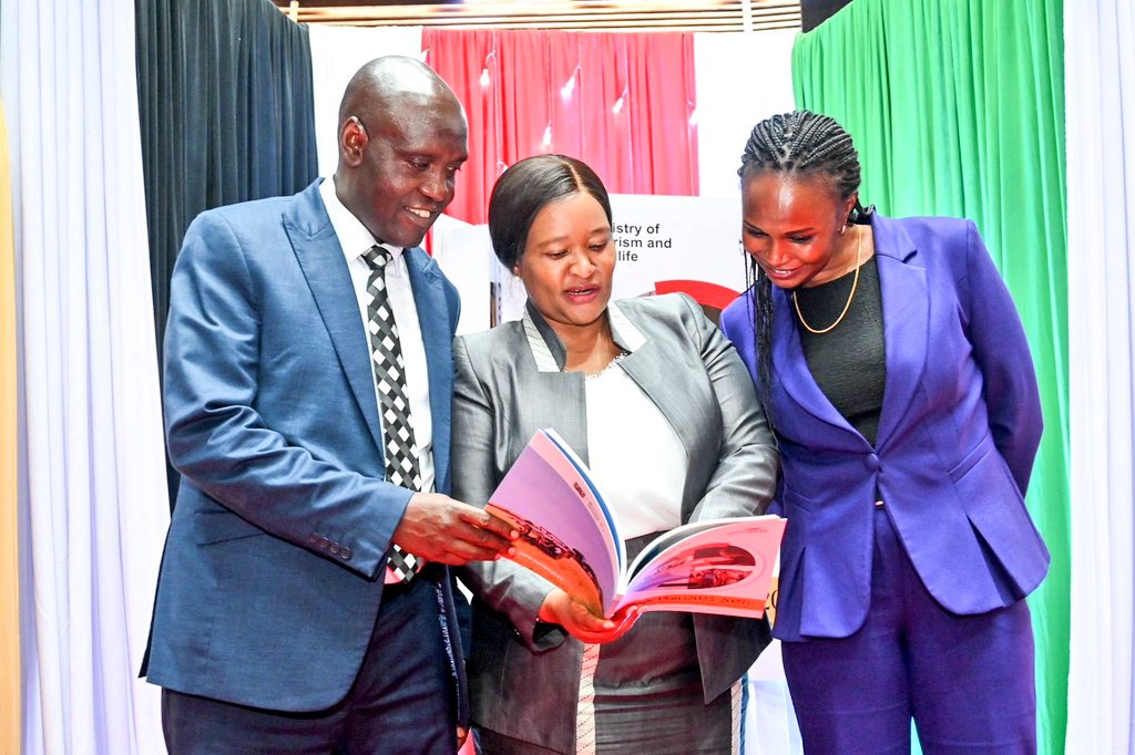 The Cabinet Secretary for Tourism and Wildlife, Hon. Rebecca Miano (centre), The Principal Secretary State Department for Tourism, John Ololtuaa (left), and the Principal Secretary State Department for Wildlife, Silvia Museiya (right), going through the Strategic Plan..
