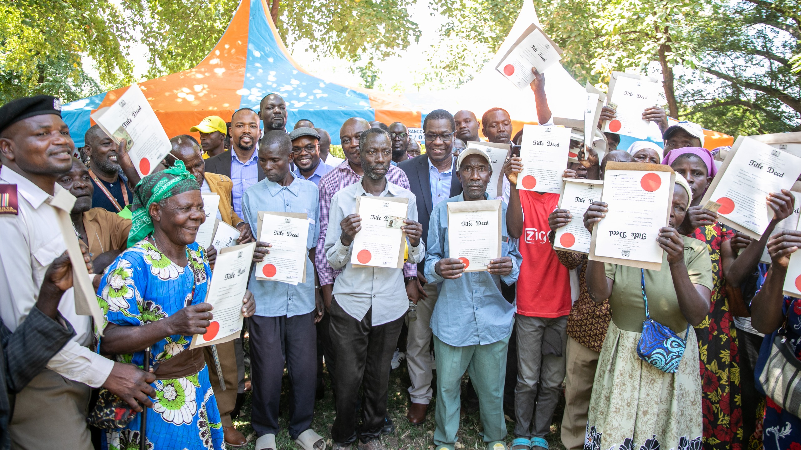 Residents of Nyagwethe display their acquired land title deeds. 