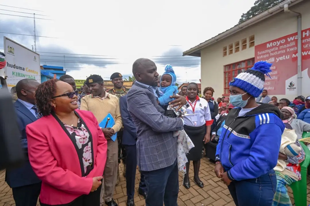  Interior CS Kipchumba Murkomen holds a baby just issued with a birth certificate at Kerugoya Huduma Centre, accompanied by Governor Anne Waiguru.   