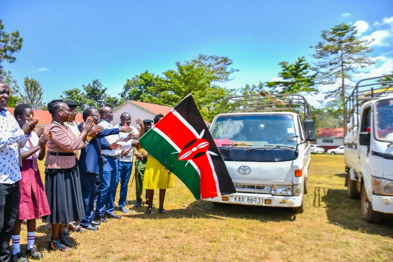 Principal Secretary for Economic Planning Bonface Makokha flagging off trucks with food donated to schools during the launch of secondary schools feeding programme in Busia PHOTO: RODGERS OMONDI