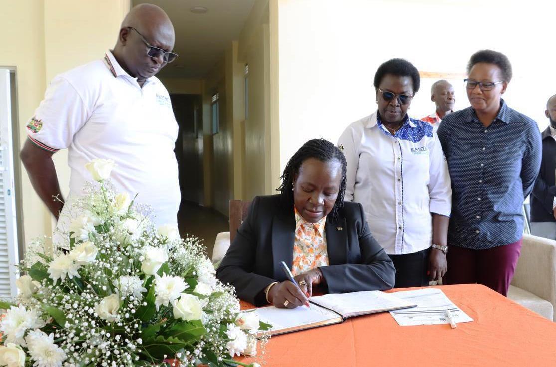 State Department for Technical Vocational Education and Training (TVET) Principal Secretary (PS) Dr. Esther Thaara Muoria (sited) signing a visitor’s book when she led the East Africa Skills for Transformation and Regional Integration Project (EASTRIP) on an inspection tour of the Sh1.2 billion textile technology factory, which has been under construction at the Kisumu National Polytechnic project on Monday.