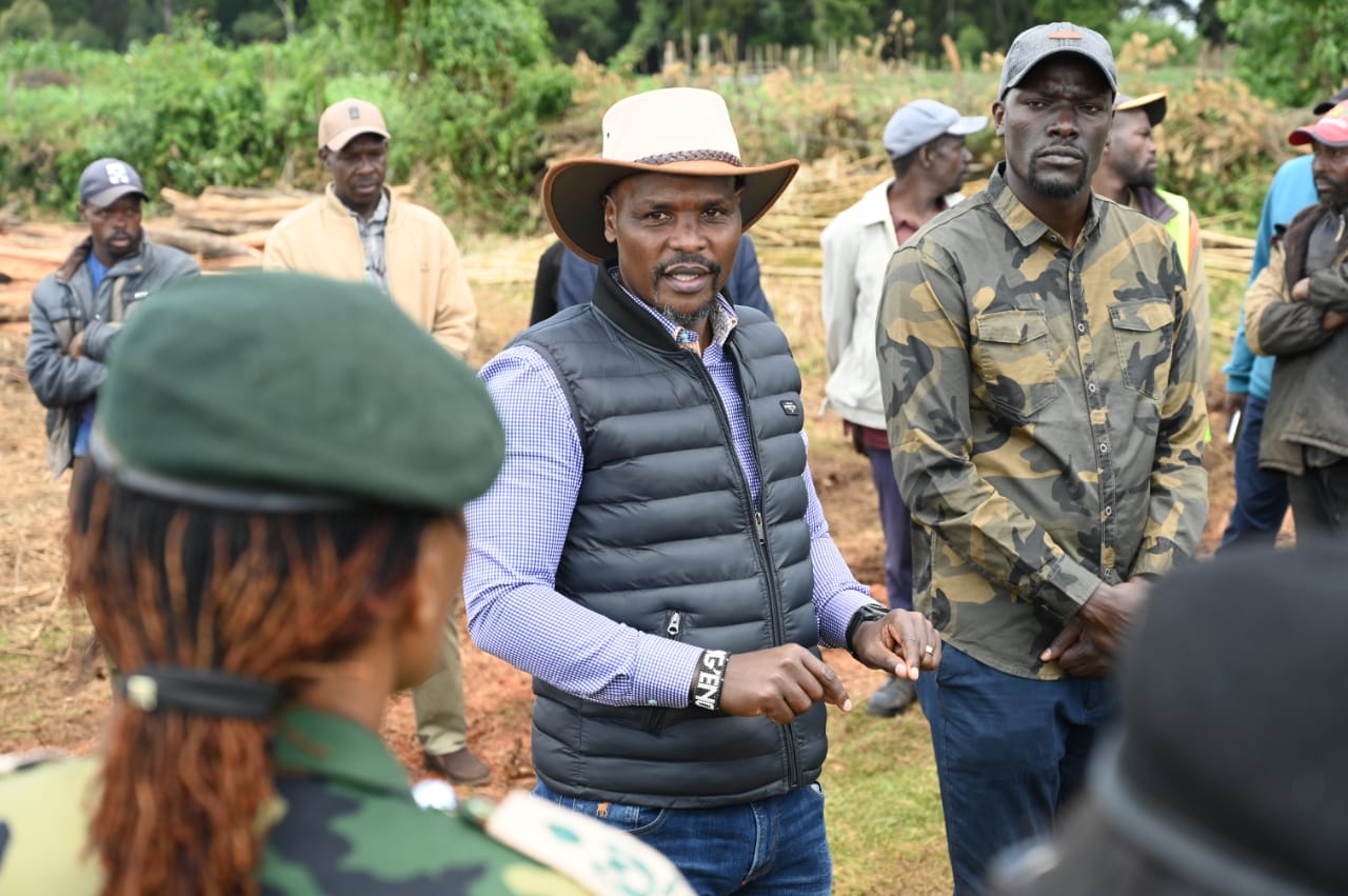 The Principal Secretary for State Department for Environment and Climate Change, Dr. Eng. Festus Ng’eno (centre) waters a tree during a planting exercise in Kuresoi, Nakuru County.
