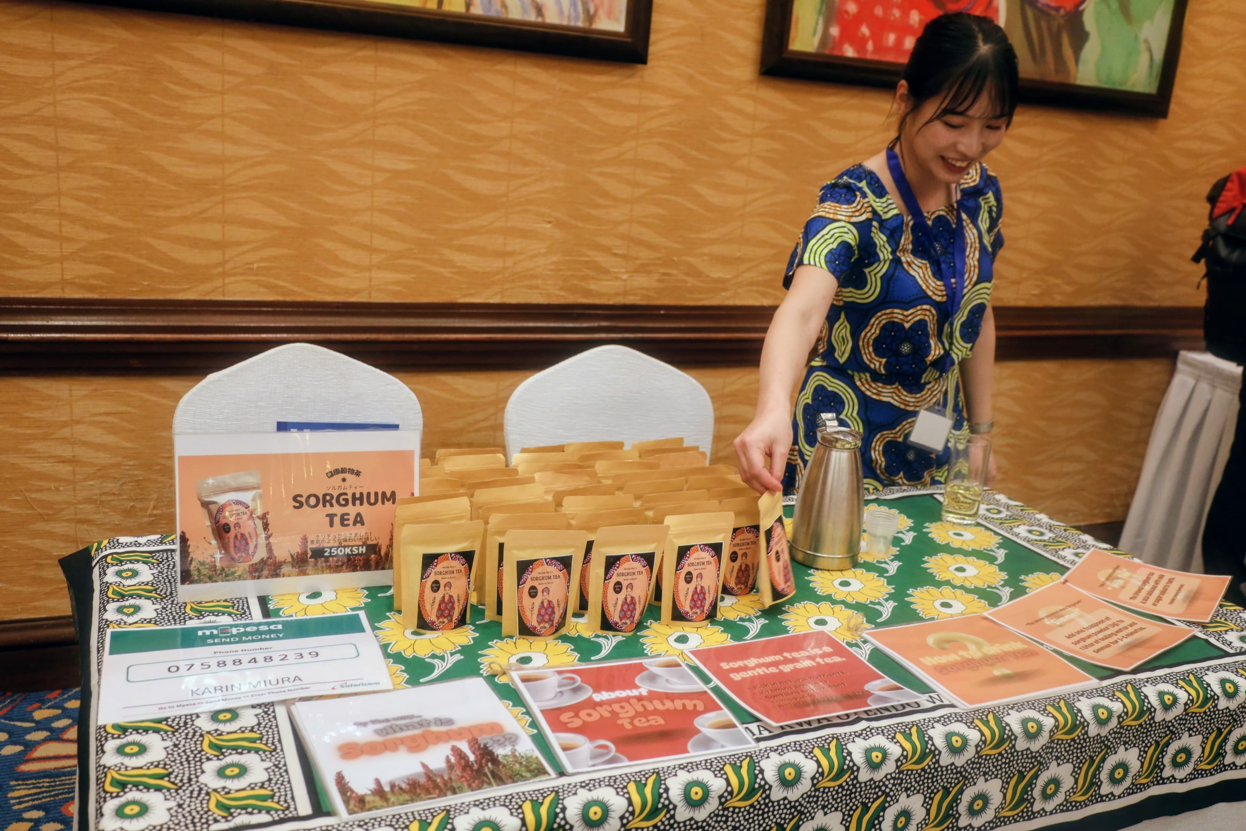 A Japanese lady presenter showcasing tea and flower seeds during the Japan International Cooperation Agency (JICA) Volunteer programme