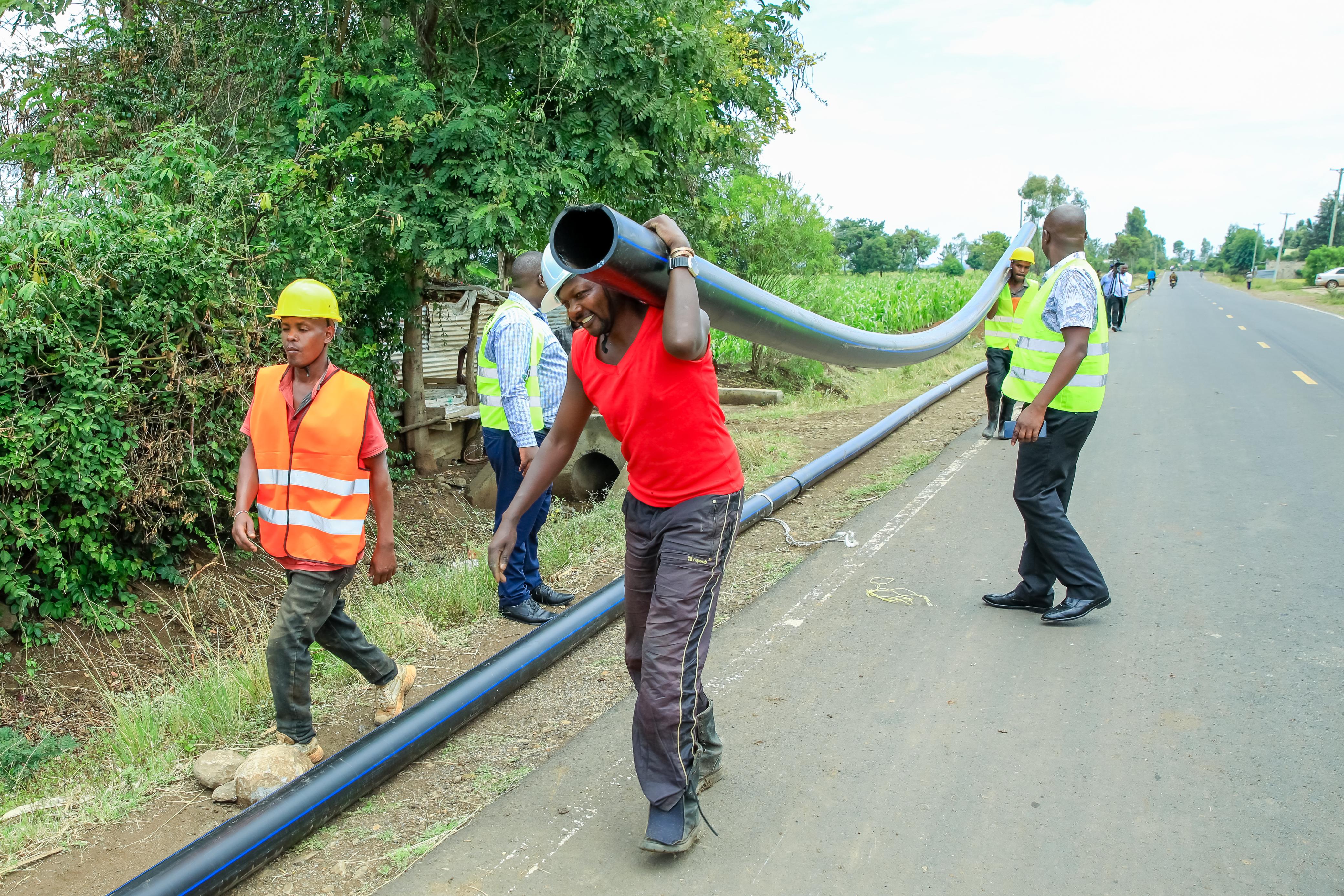 Workers carrying water pipes in a project being undertaken by the Kirinyaga County Government to supply water to Mwea Sub-County.