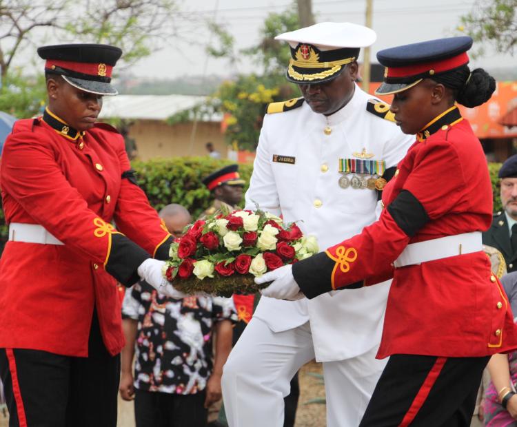 The Deputy Commander of the Kenya Navy, Brigadier John Kiswaa (in white) holding a bouquet of flowers ready to place it at the World War I cemetery in Voi.