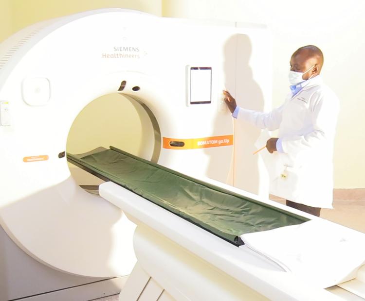 A doctor at the Kilifi County Referral Hospital illustrates how the 64 slice CT scan machine works. 