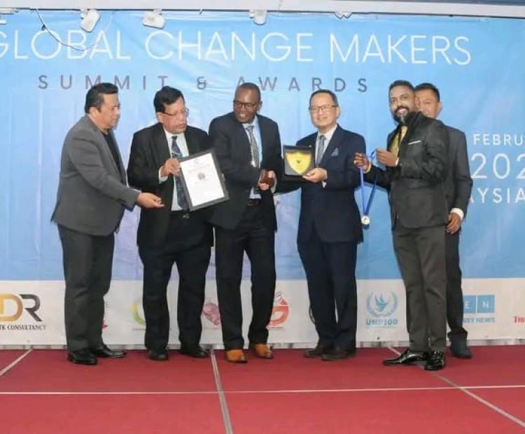 Julius Mwenda at the Police Headquarters in Nairobi as he receives some of the awards from Principal Assistant to the Inspector General Mathew Kutoh. Photo/Anne Kangero