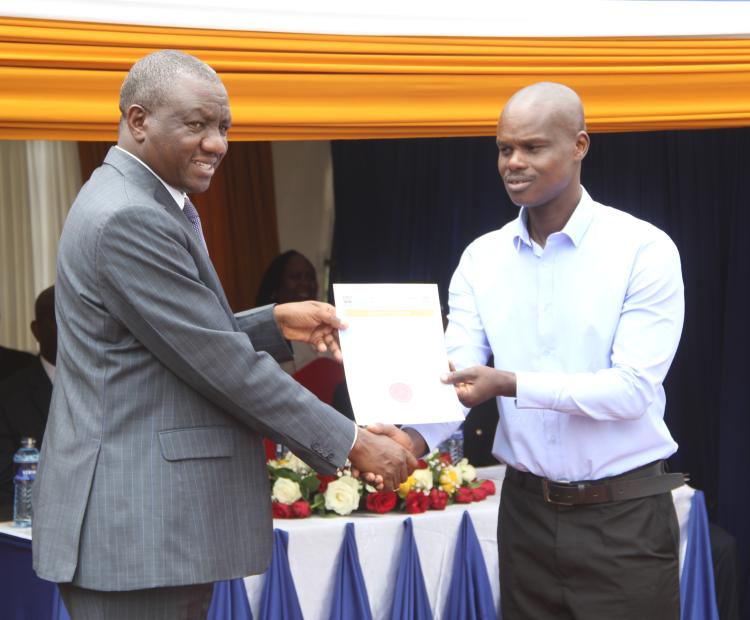 The Secretary, Human Resource Service, at the Ministry of Public Service and Human Capital Development, Dr. Jacob Mbijiwe, presented the Engineering Technologist certificate to Siele Edwin Kingetich, during the launch of the KTRB services at the Eldoret Huduma Centre