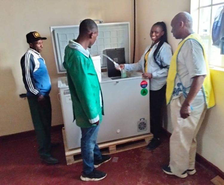 Biomedical engineers from the County Government of Nakuru pose with a solar powered vaccine storage refrigerator they installed at Munanda Dispensary in Gilgil Sub-County