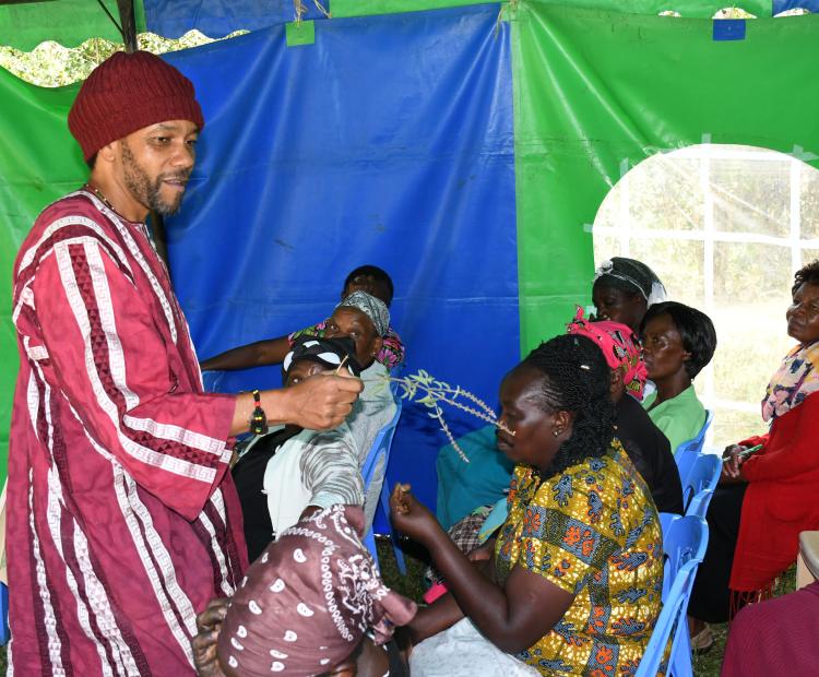  Gakiria Nderitu, a member of the team that is running the Technical Skills and Development Programme at JKUAT shows members of Wirugamie Karundas Widows Self Help Group a lavender branch. 